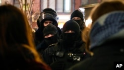 Police officers look at demonstrators in St. Petersburg, Russia, Feb. 24, 2022. Hundreds of people gathered in Moscow and St. Petersburg on Thursday, protesting against Russia's attack on Ukraine.