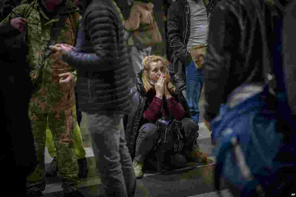 A woman reacts as she waits for a train trying to leave Kyiv, Ukraine, after Russian troops launched their attack on the country.