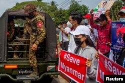 FILE - A soldier steps out of a military vehicle outside Myanmar's Central Bank during a protest against the military coup, in Yangon, Myanmar, Feb. 15, 2021.