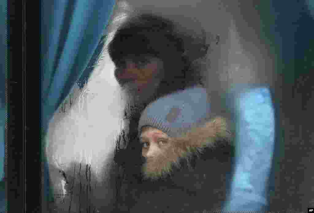 Una mujer y un niño al interior de un autobús mientras salen de&nbsp;Sievierodonetsk, en la región de Luhansk, en el este de Ucrania, el jueves 24 de febrero de 2022.&nbsp;