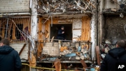 A man inspects the damage at a building following a rocket attack on the city of Kyiv, Ukraine, Feb. 25, 2022.