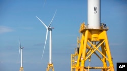 FILE - Three of Deepwater Wind's five turbines, a kind of engine, stand in the water off Block Island, Rhode Island on August 15, 2016. It is the United States' first offshore wind farm. (AP Photo/Michael Dwyer, File)