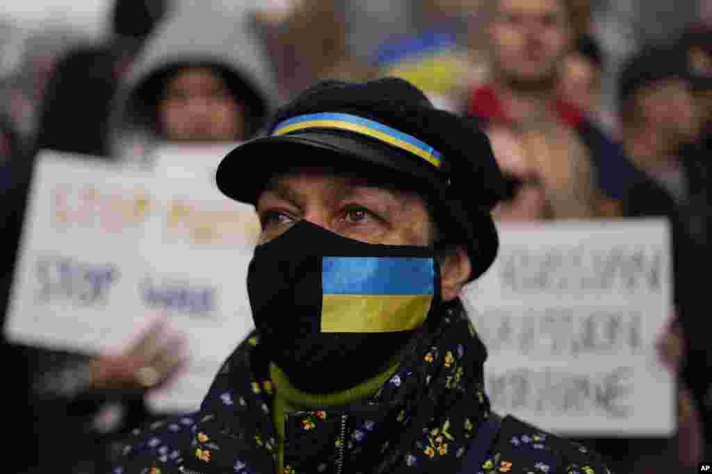 A demonstrator wears a face mask with a Ukrainian flag , as she attends a demonstration outside Downing Street, in London, Feb. 24, 2022.
