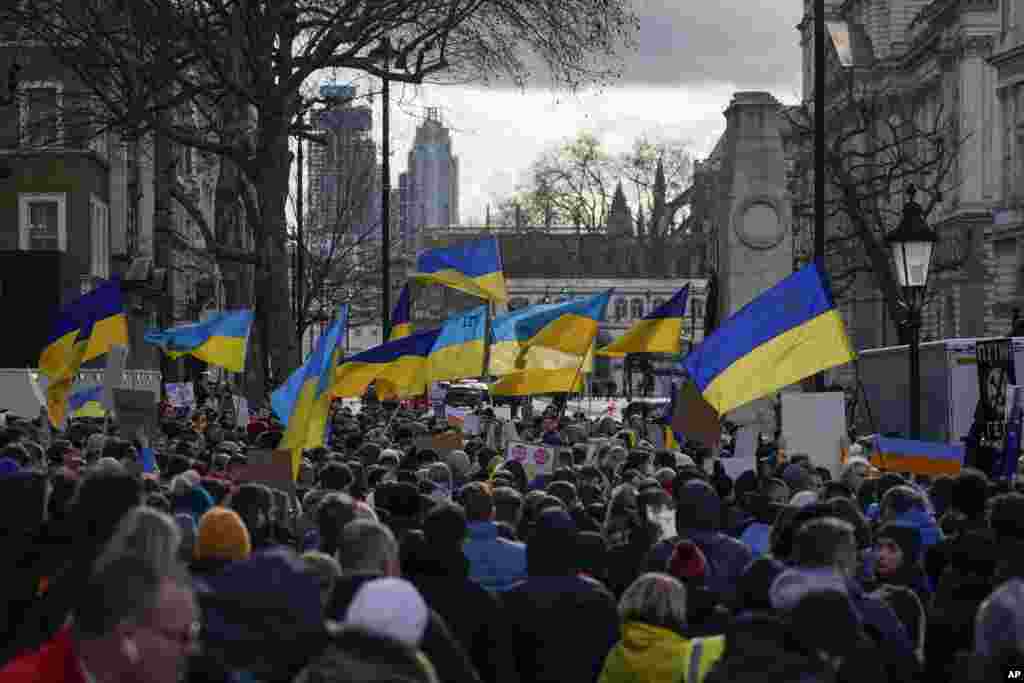 People hold placards and Ukrainian flags as they attend a demonstration in support of Ukraine, outside Downing Street, in London, Feb. 24, 2022.