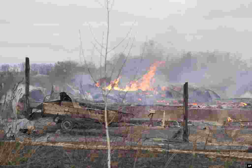 Flame and smoke rise from the debris of a private house in the aftermath of Russian shelling outside Kyiv, Ukraine, Feb. 24, 2022.