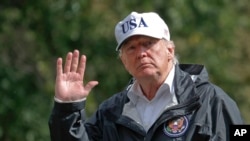 President Donald Trump waves as he arrives at the White House, Sept. 14, 2017, in Washington. Trump is returning from Florida after viewing damage from Hurricane Irma.