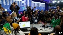 FILE— A ANC representative, left, looks on on the results board at the Results Operation Centre (ROC) in Midrand, Johannesburg, South Africa, June 1, 2024. 