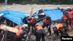 Polisi paramiliter mencari orang-orang yang hilang di lokasi tanah longsor di Sanming, provinsi Fujian, China (8/5). 