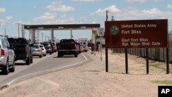 FILE - Cars wait to enter Fort Bliss in El Paso, Texas. 