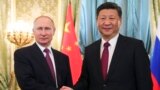 Russian President Vladimir Putin, left, shakes hands with the Chinese President Xi Jinping during a meeting in the Kremlin, in Moscow, Russia, July 4, 2017. 