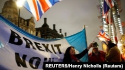 United Kingdom, London, A woman waves a British flag on Brexit day in London