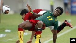 Le camerounais Henri Bedimo Nsame, premier plan, en duel avec le capitaine égyptien Ahmed Hassan lors des quarts de finale de la CAN 2010 au stade national d'Ombaka, à Benguela, en Angola, le 25 janvier 2010. 