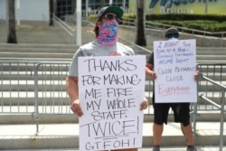 FILE - Restaurant workers and supporters gather to protest new measures stating restaurants must close their indoor seating to combat the rise in coronavirus cases, July 10, 2020 in Miami.