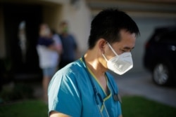 FILE - Dr. Tien Tan Vo leaves after talking with a family quarantining after they tested positive for the coronavirus July 23, 2020, in Calexico, California.