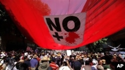 People carrying signs reading 'Stop the War' , ' No More Violence' and Mexican flags march against gang violence in Mexico City, May 8, 2011