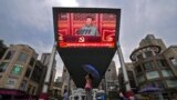 People walk past a large video screen outside a shopping mall showing Chinese President Xi Jinping speaking during an event to commemorate the 100th anniversary of China's Communist Party at Tiananmen Square in Beijing, Thursday, July 1, 2021. China…