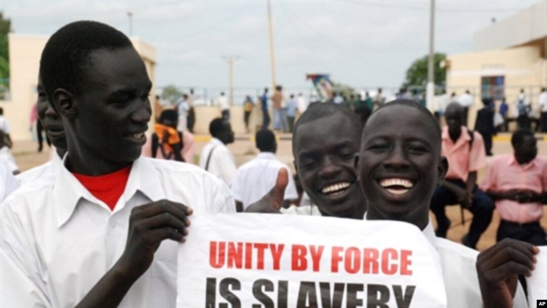 چه‌ند هاوڵاتیـیه‌کی باشوری سودان دروشمێـکیان به‌رزکردۆته‌وه‌ و له‌سه‌ری نوسراوه‌ "یه‌کێتیـیه‌کی به‌ زۆر کۆیله‌داریـیه‌"، چوارشه‌ممه‌ 6 ی ده‌ی 2010