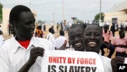چه‌ند هاوڵاتیـیه‌کی باشوری سودان دروشمێـکیان به‌رزکردۆته‌وه‌ و له‌سه‌ری نوسراوه‌ "یه‌کێتیـیه‌کی به‌ زۆر کۆیله‌داریـیه‌"، چوارشه‌ممه‌ 6 ی ده‌ی 2010