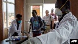 FILE - Passengers from an international flight are given a temperature screening at Juba International Airport in Juba, South Sudan, Jan. 31, 2020. 