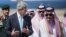 U.S. Secretary of State John Kerry, left, and Saudi Foreign Minister Saud al-Faisal walk together upon Kerry's arrival at King Abdulaziz International Airport in Jeddah, Saudi Arabia, June 27, 2014.