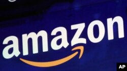 FILE - The logo for Amazon is displayed on a screen at the Nasdaq MarketSite, July 27, 2018.