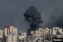 Dim se izdiže iznad stambenih zgrada nakon izraelskuh udara na Gau, 7. otobra 2023.