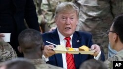 President Donald Trump holds up a tray of Thanksgiving dinner during a surprise Thanksgiving Day visit to the troops,Nov. 28, 2019, at Bagram Air Field, Afghanistan.