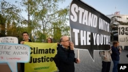 Protestors stand outside the European Court of Human Rights, where six young people from Portugal are accusing 32 European governments of violating their human rights for what they say is a failure to adequately address climate change, Sept. 27, 2023.