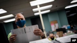 Petugas pemungutan suara memilah surat suara lebih awal dan tidak hadir di Gedung Kenosha pada Hari Pemilihan pada hari Selasa, 3 November 2020, di Kenosha, Wis. (Foto: AP/Wong Maye-E)