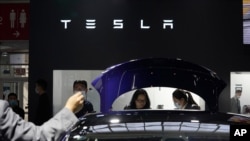 지난 9월 중국 베이징에서 열린 자동차 박람회에서 참석자들이 테슬라의 전기 자동차를 보고 있다. 