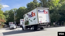 FedEx vans carrying two giant pandas sent by China arrive at the National Zoo in Washington, Oct. 15, 2024. (Teng Xu/VOA)