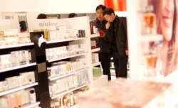 Men look at cosmetic products in a Duty Free store at the Fraport airport in Frankfurt, Germany, Nov. 14, 2012.