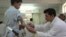 An Afghan technician helps a young amputee adjust his prosthetic arm at one of the International Committee of the Red Cross (ICRC) hospitals for war victims and the disabled in Jalalabad on June 26, 2012.
