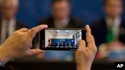 Un hombre toma una fotografía con su teléfono celular durante una reunión del Acuerdo Integral y Progresista de Asociación Transpacífico, CP TPP.