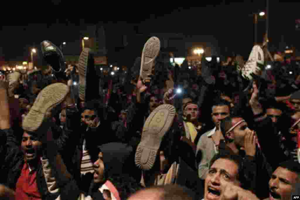 Anti-government protesters hold their shoes as they react to Egyptian President Hosni Mubarak's televised statement to his nation in Tahrir Square in downtown Cairo, Egypt Thursday, Feb. 10, 2011. Egyptian President Hosni Mubarak announced he is handing