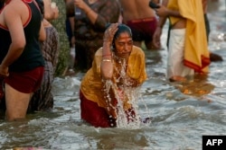 A pilgrim takes a holy dip in the confluence of the Ganges and Yamuna rivers during the Maha Kumbh Mela festival in Prayagraj, India, on Feb. 12, 2025.