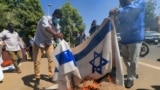 FILE - Sudanese demonstrators burn an Israeli flag during a rally against their country's recent signing of a deal on normalizing relations with the Jewish state, outside the cabinet offices in the capital Khartoum, on Jan. 17, 2021. 