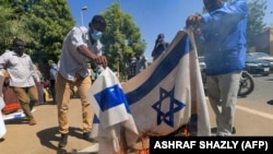 FILE - Sudanese demonstrators burn an Israeli flag during a rally against their country's recent signing of a deal on normalizing relations with the Jewish state, outside the cabinet offices in the capital Khartoum, on Jan. 17, 2021. 