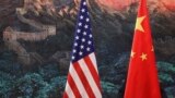 A Chinese man adjusts a China flag before a news conference attended by Chinese Foreign Minister Yang Jiechi and U.S. Secretary of State Hillary Clinton at the Great Hall of the People in Beijing September 5, 2012. China and the United States were divided