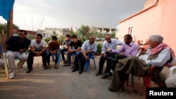 Turkish Kurdish men chat in the village of Doruklu, in the border town of Silopi, near the Turkish-Iraqi border, July 5, 2014. 