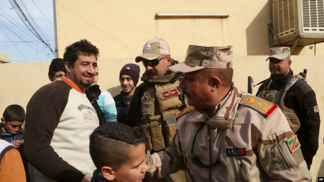 Warga memberi ucapan selamat kepada Letjen Riyadh Jalal Tawfiq (dua dari kanan), komandan pasukan darat Iran saat pasukan keamanan sedang berpatroli di wilayah timur kota Mosul, Irak, 18 Januari 2017. (AP Photo/ Khalid Mohammed). 