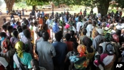 FILE - A U.N. refugee agency official speaks to civilians during a distribution of food items in Yei, in southern South Sudan, Nov. 15, 2016. The formerly peaceful town of Yei became a center of country's renewed civil war, gripped by killings among the dozens of ethnic groups.