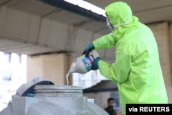 FILE - A member of a medical team wears a protective face mask, following the coronavirus outbreak, as he prepares disinfectant liquid to sanitize public places in Tehran, Iran, March 05, 2020.