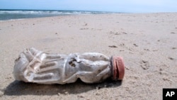 A discarded plastic bottle lies on the beach at Sandy Hook, N.J. on Tuesday, April 2, 2019. (AP Photo/Wayne Parry)