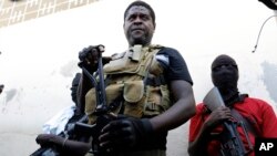 FILE — Jimmy Chérizier, known as Barbecue, the leader of the "G9 and Family" gang, stands with his fellow gang members after speaking to journalists in the Delmas 6 neighborhood of Port-au-Prince in Port-au-Prince, Haiti, on March 5, 2024.