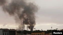 Black smoke billows above areas where pro-government forces and fighters from the Shura Council of Libyan Revolutionaries are battling in Benghazi, Dec. 11, 2014. 
