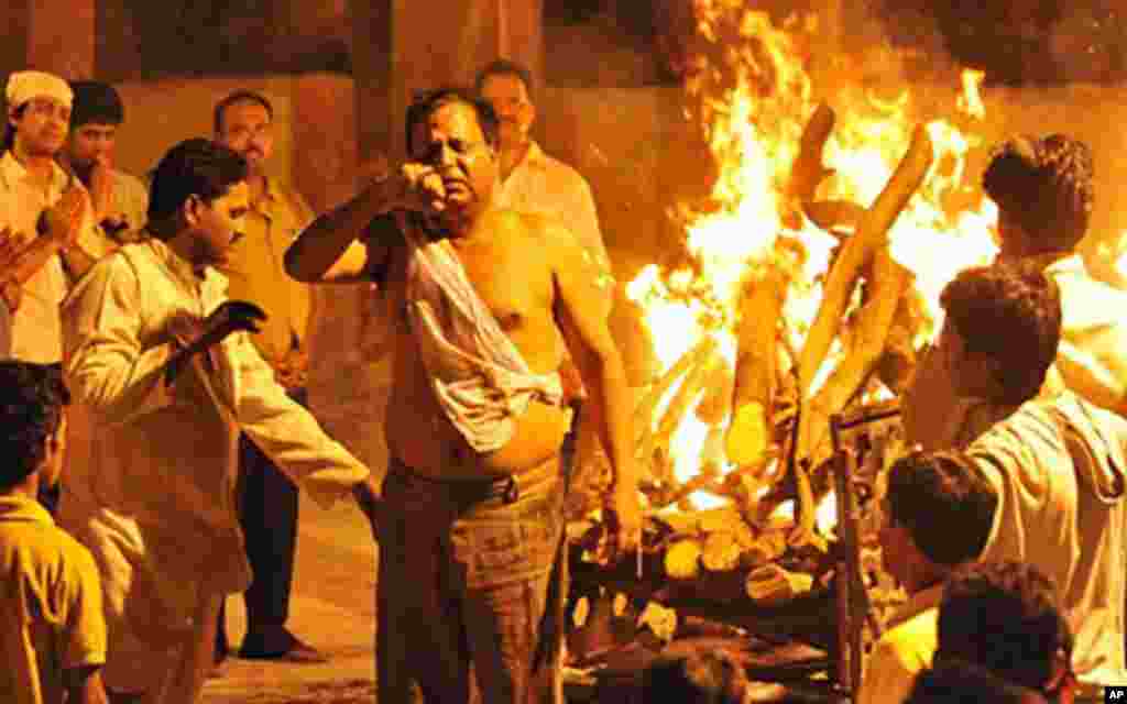 Father of Tejal Kamolkar, a member of the cabin crew of the crashed Air India Express plane, reacts during her daughter's cremation on the outskirts Mumbai, 23 May 2010