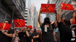 Manifestantes en Hong Kong marchan con carteles en alto que dicen "Anti-Chinanazi", el domingo 29 de septiembre de 2019.