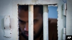 An inmate accused of being an Islamic State fighter stands inside a cell at the Syrian Democratic Forces-run Gweiran Prison, now called Panorama, in Hassakeh, northeastern Syria, Jan. 31, 2025.