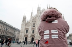 FILE - A tourist from Taiwan wears stickers on her back, in Milan, as Italy was hit by the coronavirus outbreak, Feb. 25, 2020.